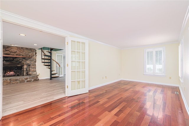 unfurnished living room with ornamental molding, a fireplace, and hardwood / wood-style floors