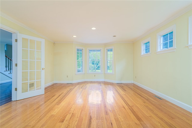 empty room featuring ornamental molding and light hardwood / wood-style floors