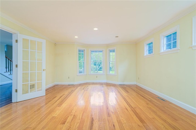 spare room with baseboards, visible vents, stairway, and light wood-type flooring