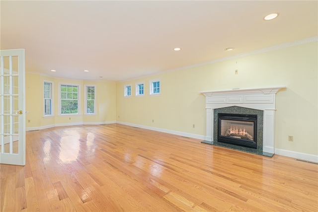 unfurnished living room with a fireplace, ornamental molding, and light hardwood / wood-style flooring