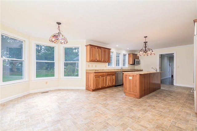 kitchen featuring an inviting chandelier, appliances with stainless steel finishes, light countertops, brown cabinetry, and baseboards