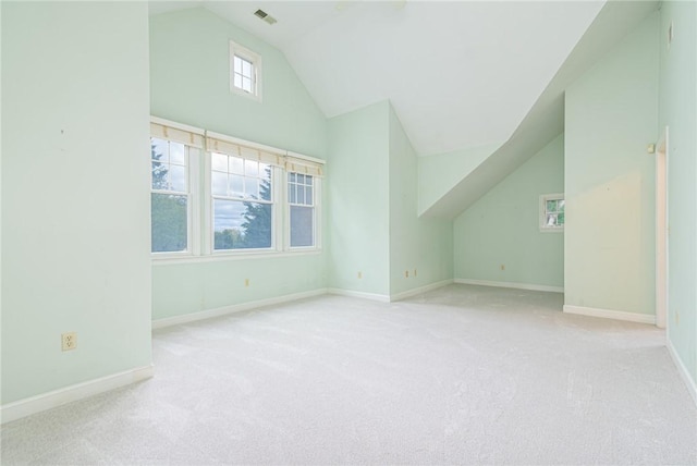 additional living space featuring visible vents, carpet flooring, baseboards, and vaulted ceiling
