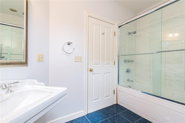 full bath with enclosed tub / shower combo, a sink, and tile patterned flooring