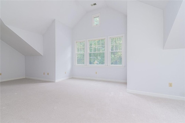 bonus room with light colored carpet, baseboards, visible vents, and high vaulted ceiling