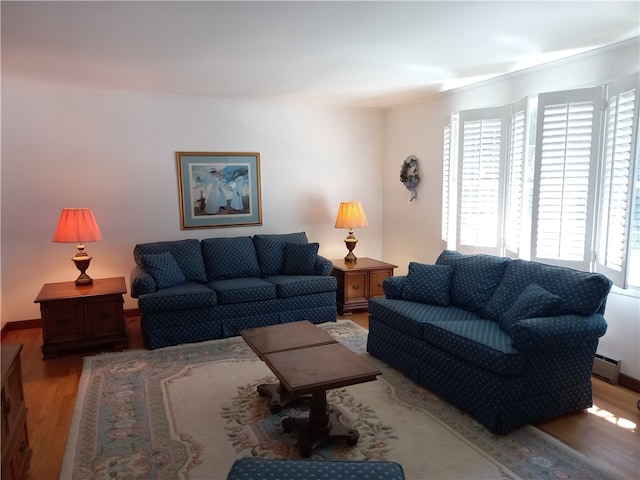 living room with baseboard heating and light hardwood / wood-style floors