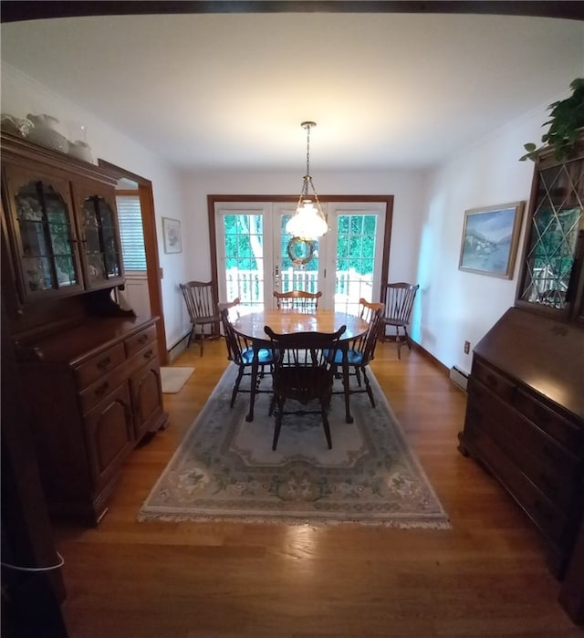 dining space featuring a baseboard heating unit and wood-type flooring