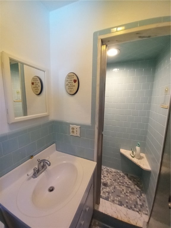 bathroom featuring a tile shower and vanity