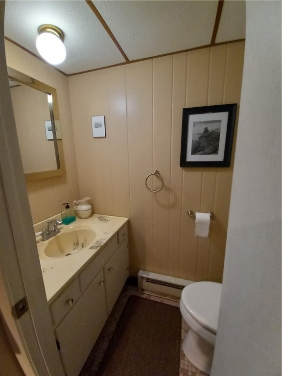 bathroom with a baseboard heating unit, a textured ceiling, vanity, and toilet