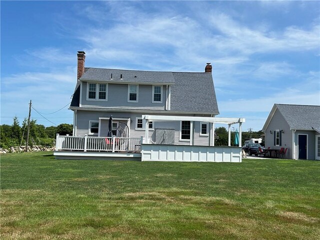 back of property with a yard and a wooden deck