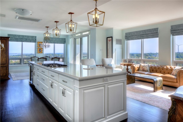 kitchen featuring dark hardwood / wood-style flooring, a wealth of natural light, a center island, white cabinetry, and hanging light fixtures