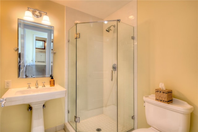 bathroom with a shower with door and toilet