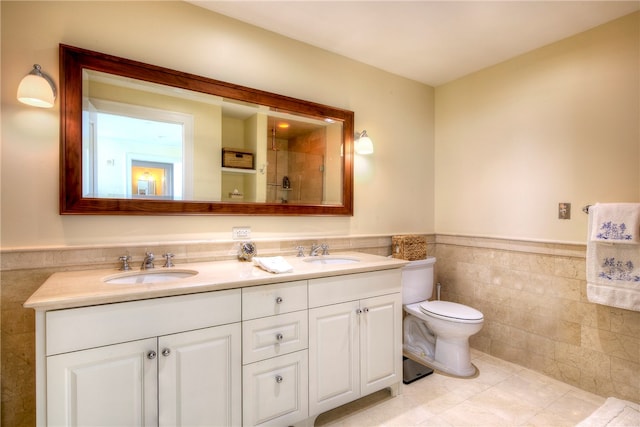 bathroom featuring tile patterned flooring, vanity, toilet, and tile walls