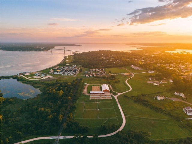 aerial view at dusk featuring a water view