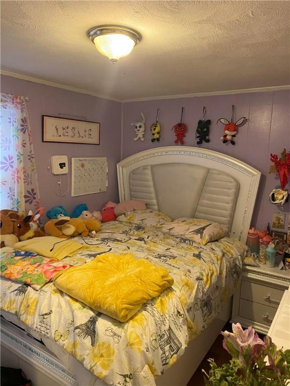 bedroom with crown molding and a textured ceiling