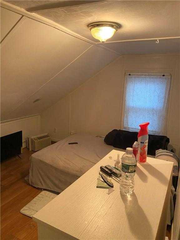 bedroom featuring lofted ceiling and hardwood / wood-style floors