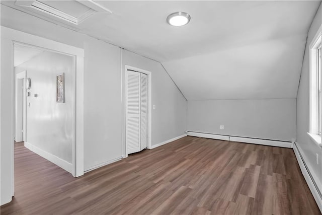 additional living space featuring a baseboard heating unit, vaulted ceiling, and hardwood / wood-style flooring