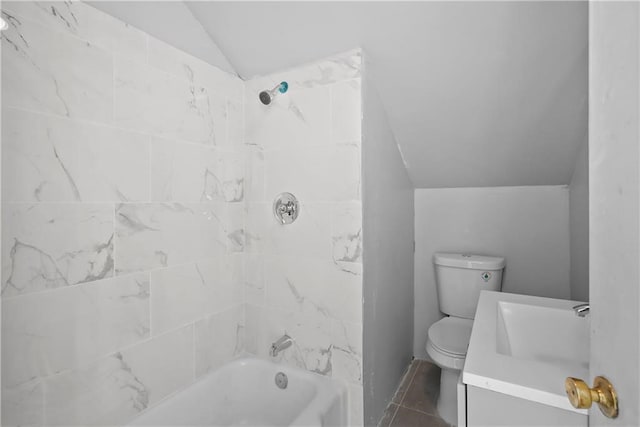 full bathroom featuring lofted ceiling, tile patterned floors, vanity, tiled shower / bath, and toilet