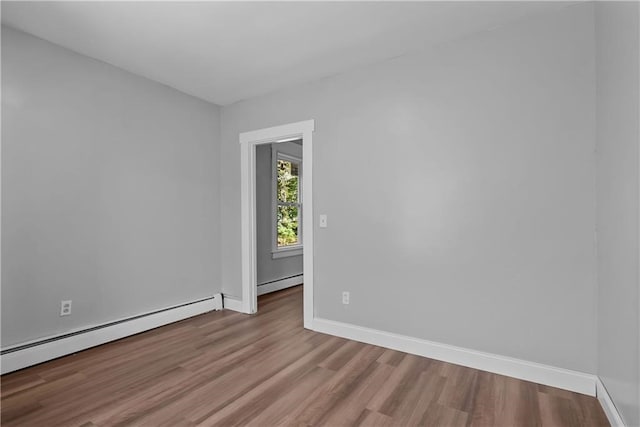 empty room featuring light wood-type flooring and baseboard heating