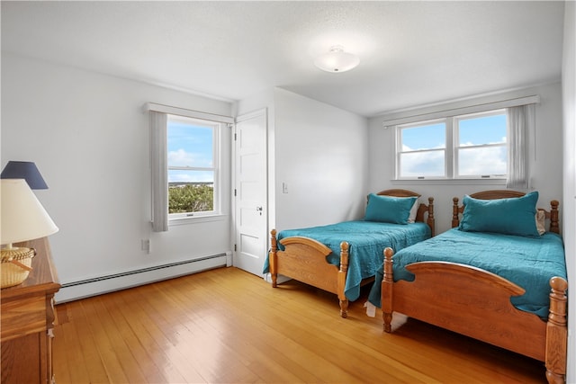 bedroom featuring wood-type flooring and baseboard heating