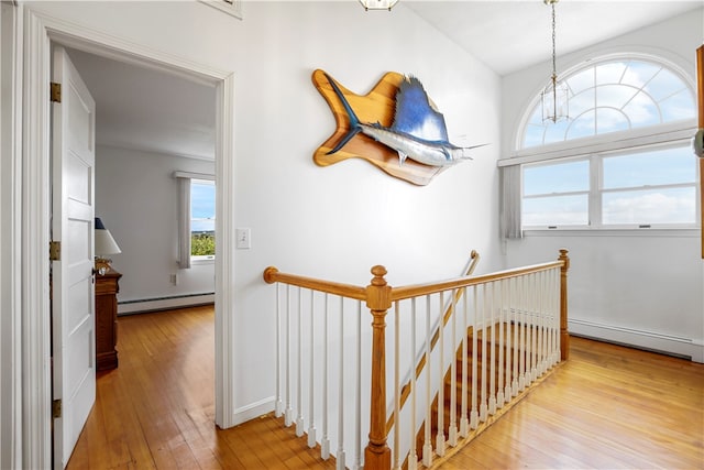 hall featuring a notable chandelier, a baseboard radiator, and light hardwood / wood-style floors