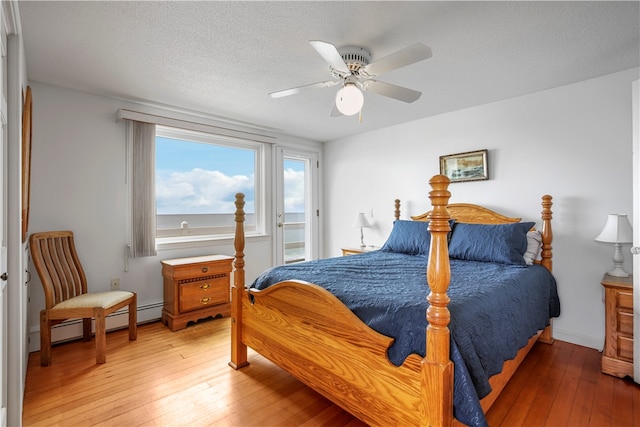 bedroom with ceiling fan, hardwood / wood-style floors, and a textured ceiling