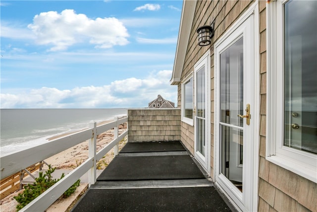 balcony featuring a view of the beach and a water view