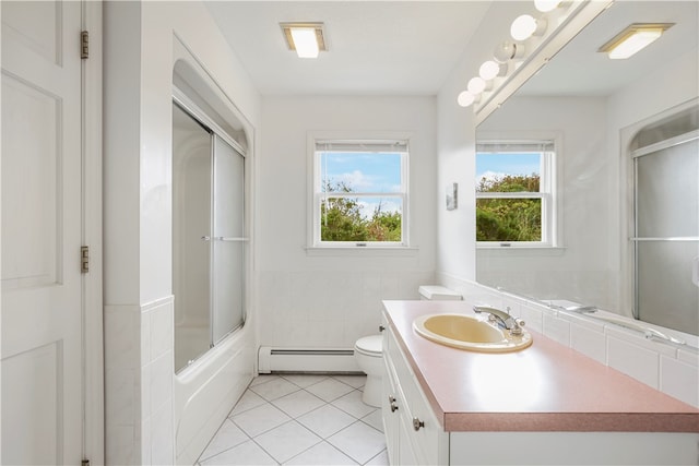 full bathroom with shower / bath combination with glass door, vanity, toilet, a baseboard radiator, and tile patterned flooring