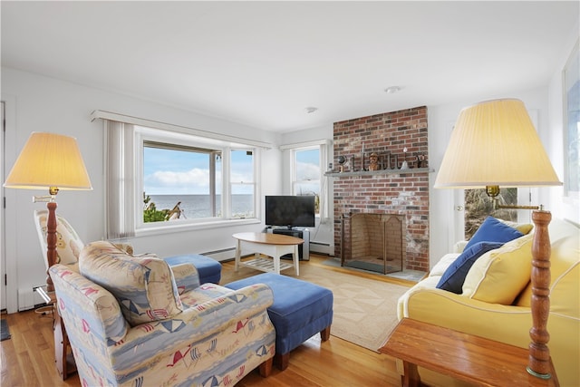 living room featuring light hardwood / wood-style floors, a fireplace, and baseboard heating