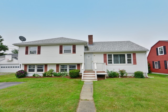 tri-level home featuring a front yard and a garage