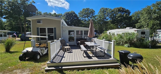 exterior space featuring a wooden deck and a lawn