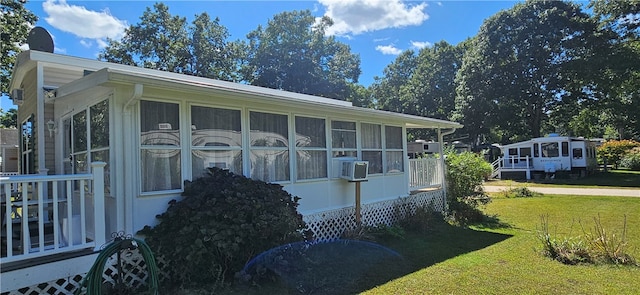 view of home's exterior with a lawn and a sunroom