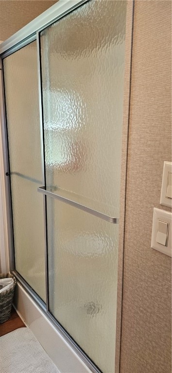 bathroom with a shower with door