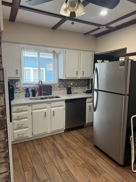 kitchen with appliances with stainless steel finishes, hardwood / wood-style floors, sink, and white cabinets