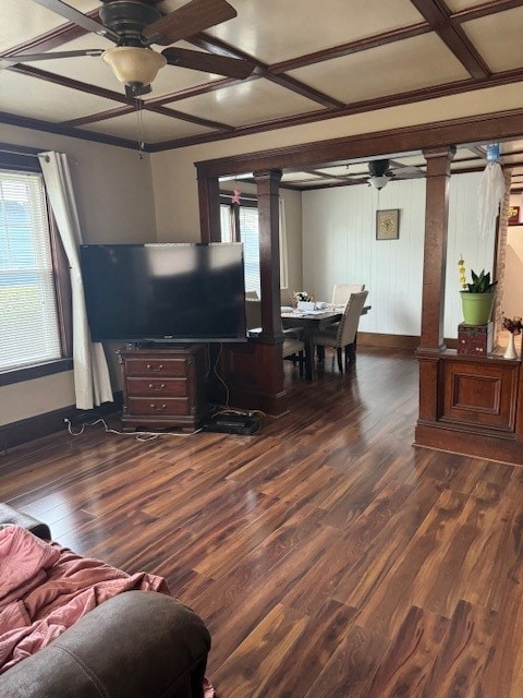 living room with dark wood-type flooring, coffered ceiling, and a healthy amount of sunlight