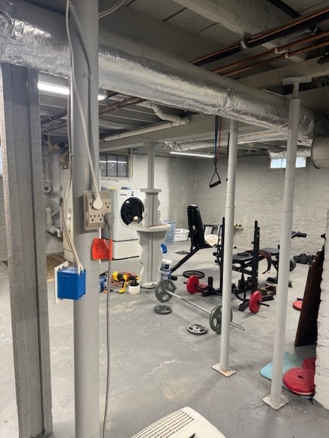 workout room featuring concrete floors and washer / dryer