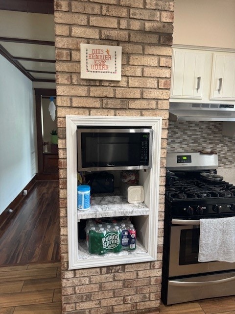 kitchen with appliances with stainless steel finishes, tasteful backsplash, white cabinets, dark hardwood / wood-style flooring, and range hood