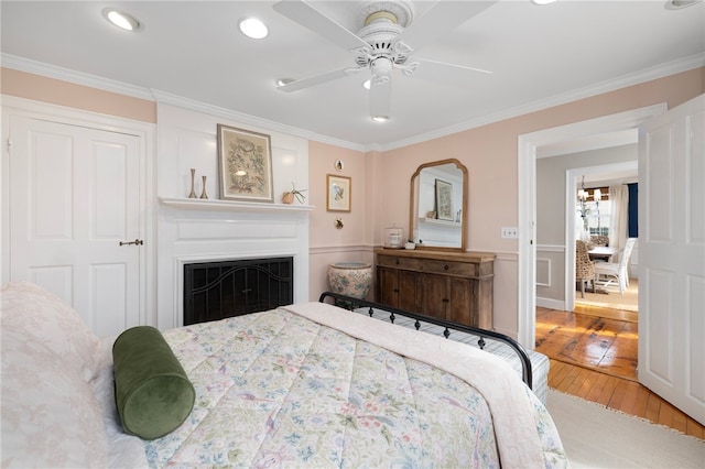 bedroom with ceiling fan, crown molding, and hardwood / wood-style floors