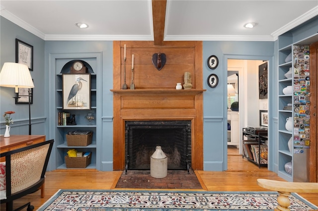 living room featuring beamed ceiling, ornamental molding, hardwood / wood-style floors, and built in features