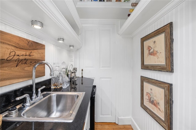 kitchen featuring crown molding, hardwood / wood-style flooring, and sink