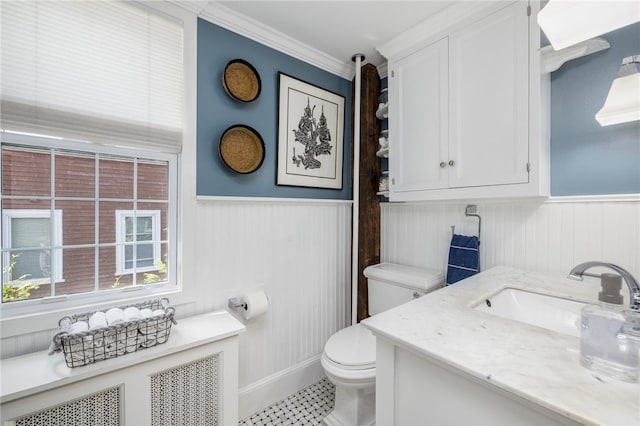 bathroom with ornamental molding, vanity, toilet, and radiator heating unit