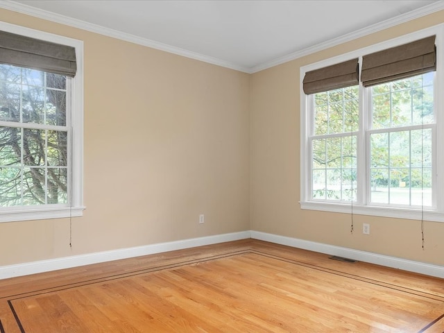 empty room with ornamental molding and hardwood / wood-style flooring