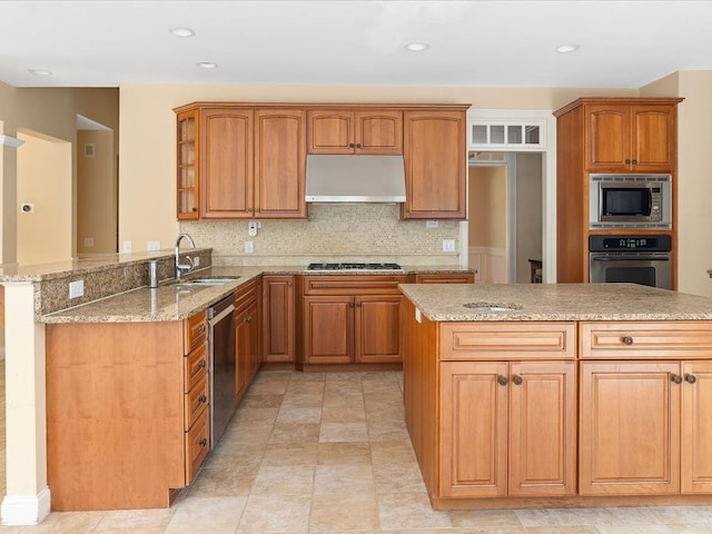 kitchen with sink, kitchen peninsula, stainless steel appliances, exhaust hood, and light stone countertops