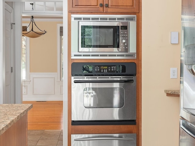 kitchen featuring appliances with stainless steel finishes and light hardwood / wood-style flooring