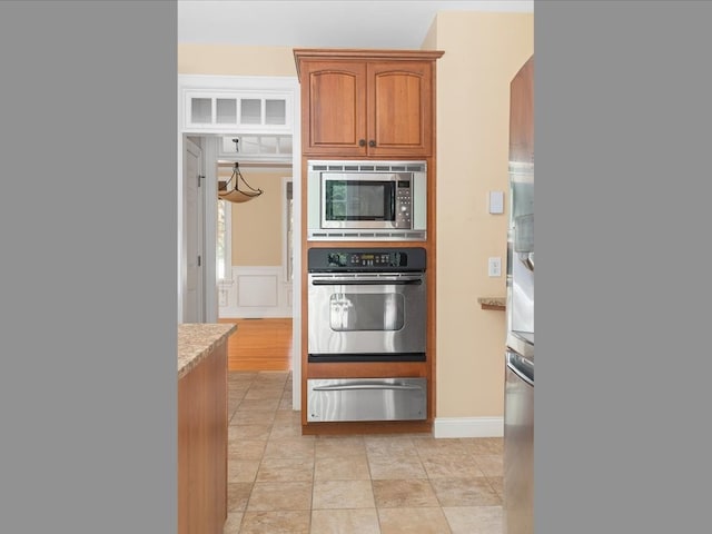 kitchen featuring light stone countertops and stainless steel appliances