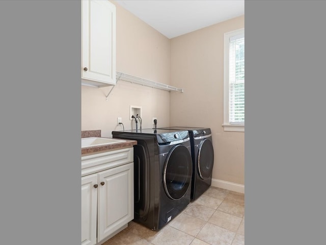 clothes washing area with cabinets, independent washer and dryer, and light tile patterned flooring