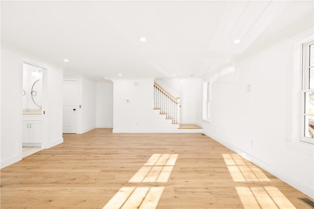 basement with crown molding and light hardwood / wood-style flooring