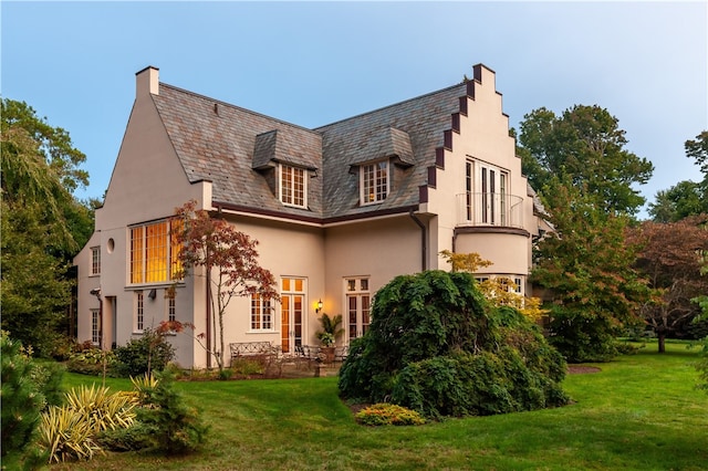 rear view of house featuring a lawn