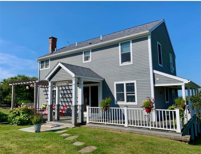 back of house with a yard and covered porch