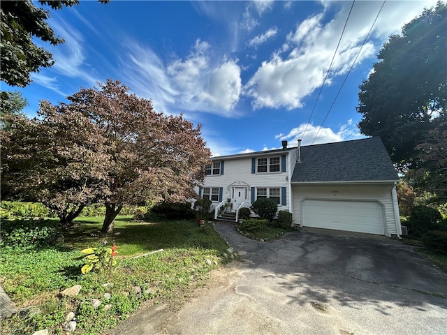 view of front facade with a garage and a front lawn