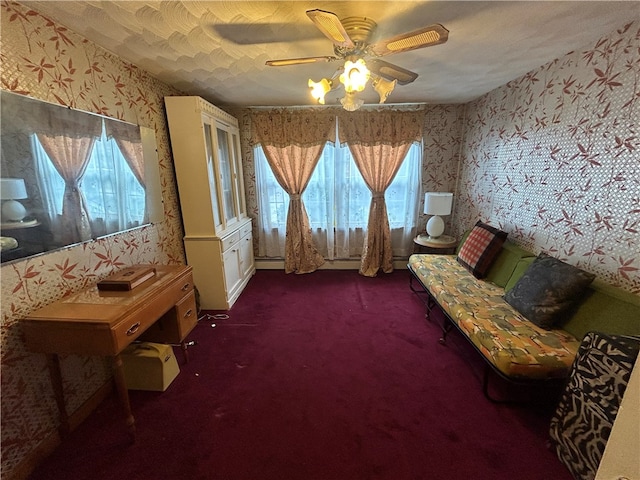 unfurnished room featuring a baseboard heating unit, a wealth of natural light, dark colored carpet, and ceiling fan